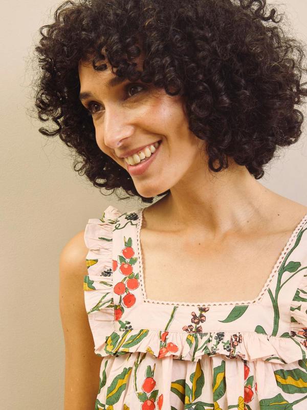Woman wearing a floral & Pear night dress against a plain background