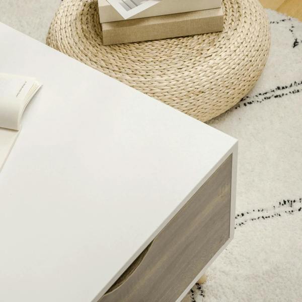 White coffee table corner with dark side panel and smooth tabletop edge