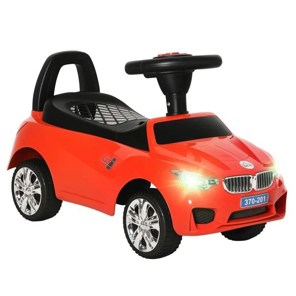 Red ride-on toy car walker with black steering handle, enclosed seat, chrome-style wheels