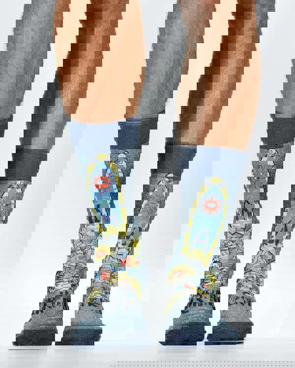 Colorful socks with surfboard design worn by a person on a white background