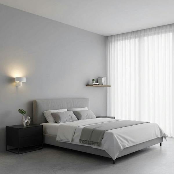 White wall mount interior light in a bedroom next to the bed on a neutral coloured wall