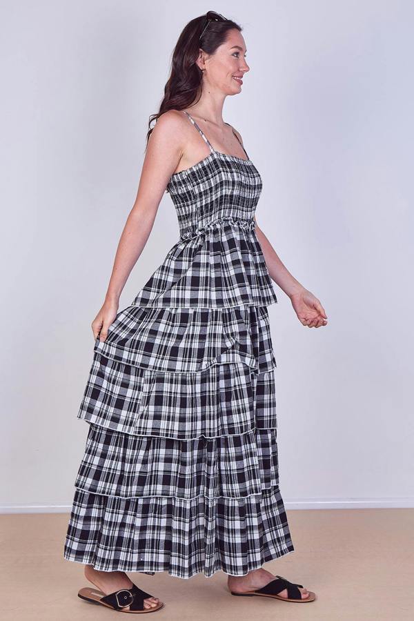 Woman wearing a black and white checkered dress against a plain background