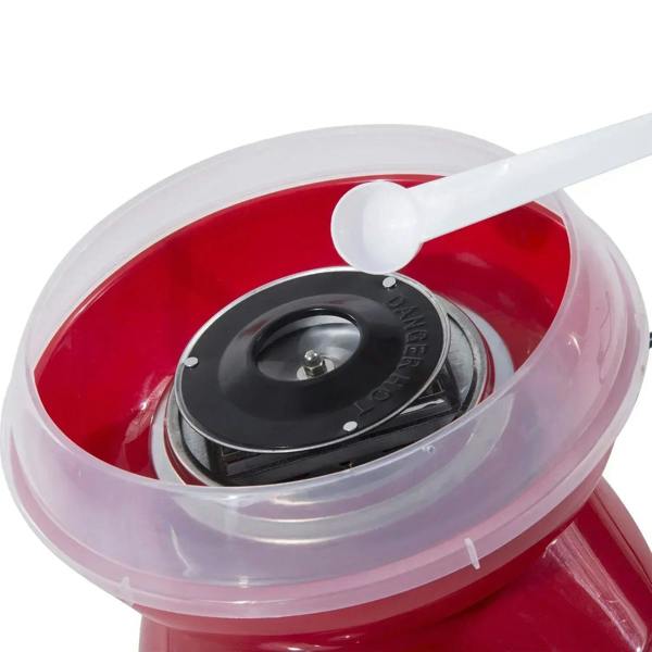 Close-up of red cotton candy machine with clear bowl lid and white measuring scoop