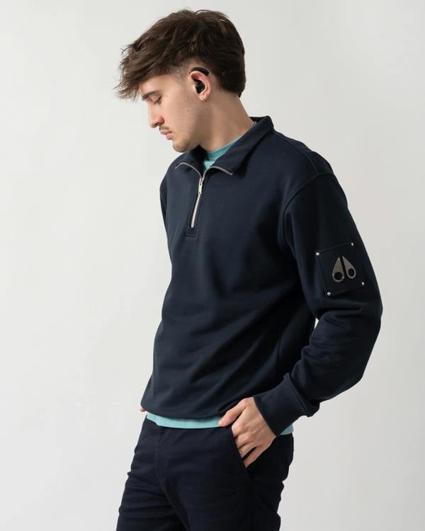 side shot of a model wearing a Moose Knuckles Hartsfield Mens quarter Zip Sweatshirt in Navy 833