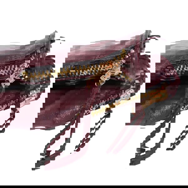 Close up detail shot of gloves displays small golden zip on the cuff, with leather tassel attached.