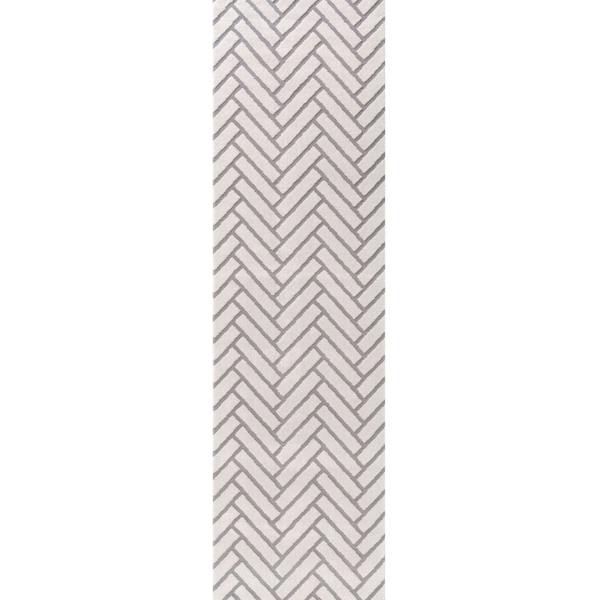 Rectangular area rug with a gray and white chevron pattern on a plain background
