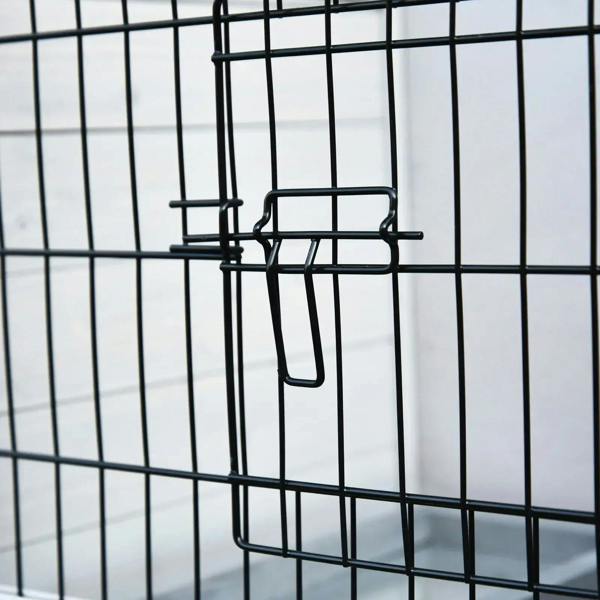 Black metal latch handle on wire mesh door of a two-tier wooden small animal hutch