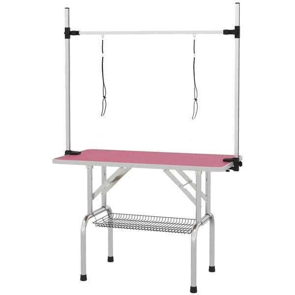 Adjustable pet grooming table with pink rubber top and metal frame, storage basket