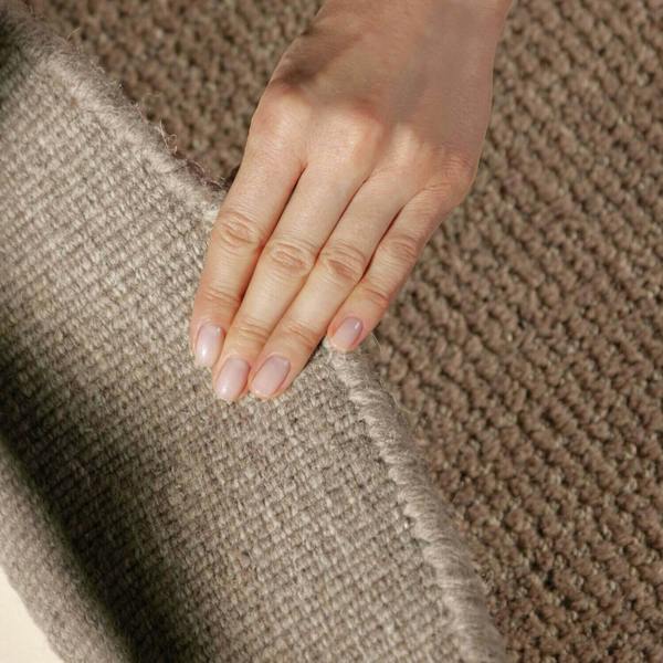 Hand touching a textured brown fabric surface
