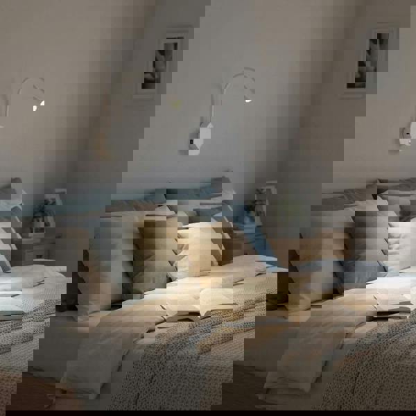 white flexible LED reading lamp installed over a bed in a modern bedroom