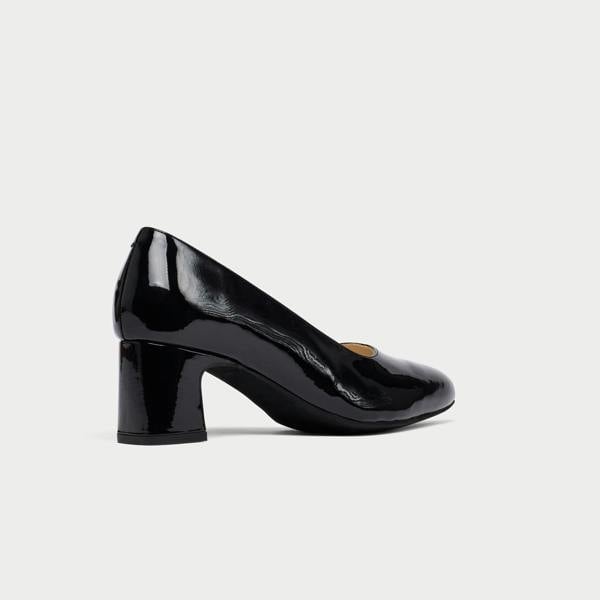 Black patent leather shoe on a light gray background