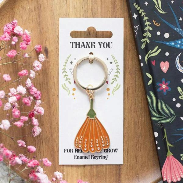 Enamel keyring on gift card, orange flower charm with gold ring and green top