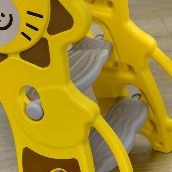 Yellow lion slide climber steps and side rails close-up detail