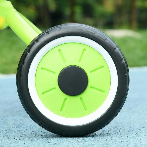 Lime green kids tricycle wheel with black tire and white rim, close-up