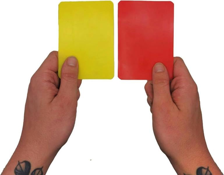 Hands holding up yellow and red referee cards against white background - Optimum