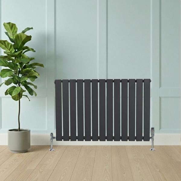 Flat single column radiator in anthracite grey, 600mm x 910mm, with sleek vertical slats and chrome valves, set against a light blue wall