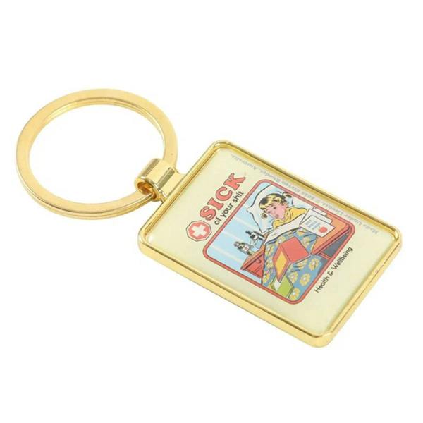 Gold keyring with square “SICK of your shit” charm, comic-style artwork on a gold frame
