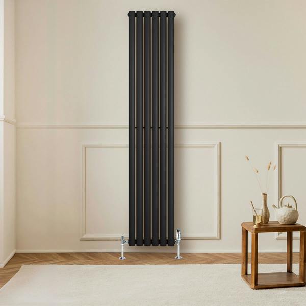 Sleek black oval single column radiator, 1800 x 360mm, mounted on a wall with stylish decor and wooden flooring in a modern room