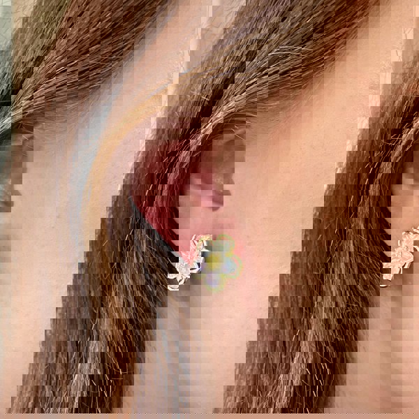 Flower clip-on earrings, iridescent petals, gold-tone outline, textured gold centre, delicate floral design, vintage-inspired jewellery, feminine accessory
