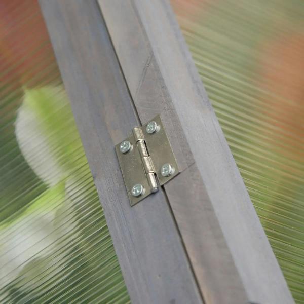 Metal hinge on grey wooden cold frame greenhouse frame