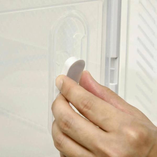 Hand pulling magnetic door handle on clear plastic shoe storage box
