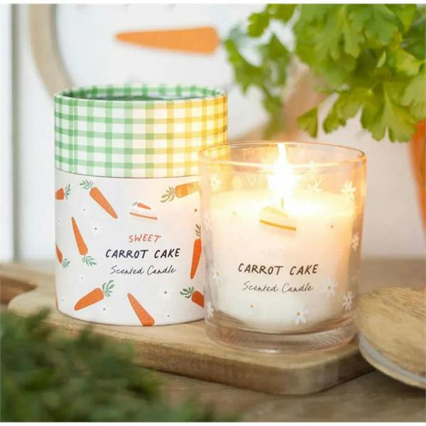 Lit carrot cake scented candle in clear glass jar with gingham lid and carrot label