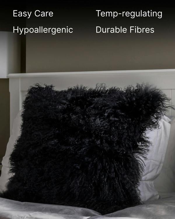 Black mongolian sheepskin pillow on bed