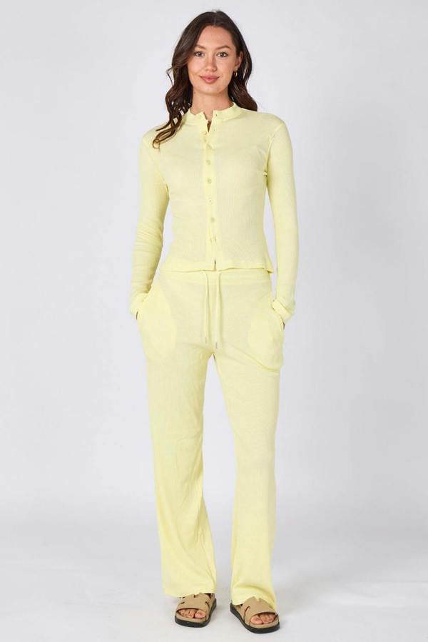 Woman wearing a light yellow outfit on a white background