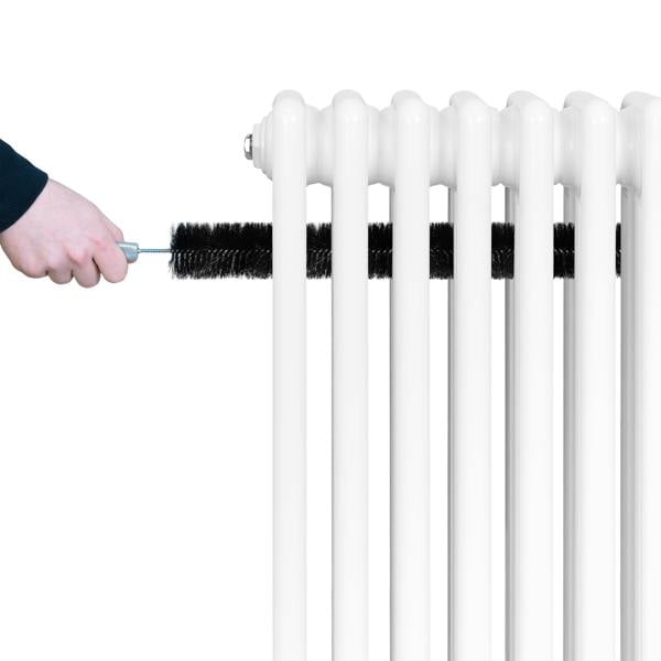 Traditional white 4 column radiator with a hand using a brush for cleaning, showcasing its smooth, glossy finish and classic design