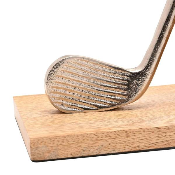 A macro close-up photograph of a metallic silver golf club head showing grooved textures on a smooth natural wooden bookend base.