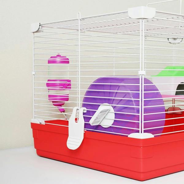 Red and white hamster cage front view with purple running wheel, water bottle, and shelter.