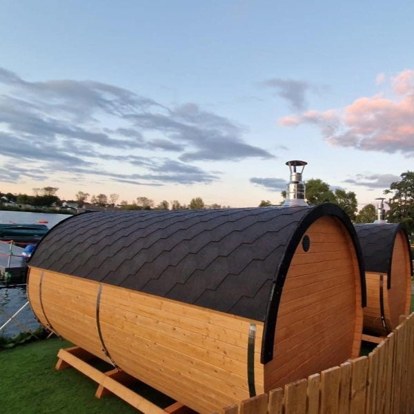 Wooden barrel saunas with a scenic sky view.