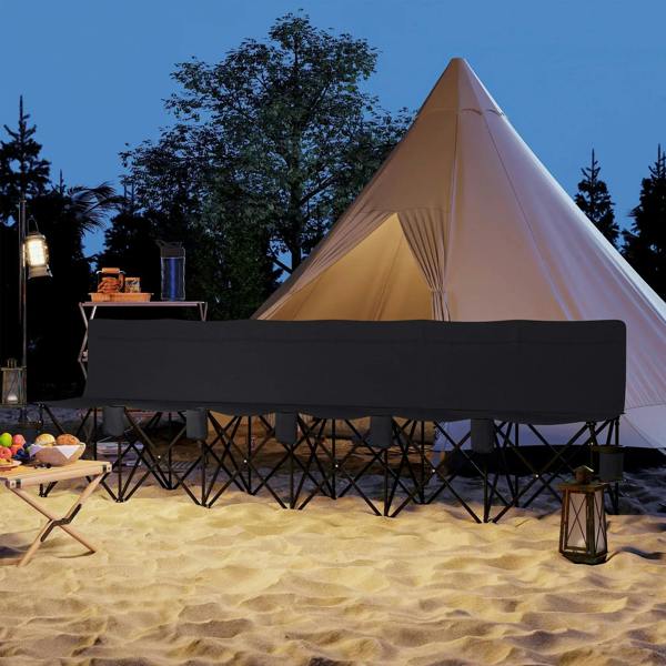 Black folding camping chair with cup holders and padded bench on sand