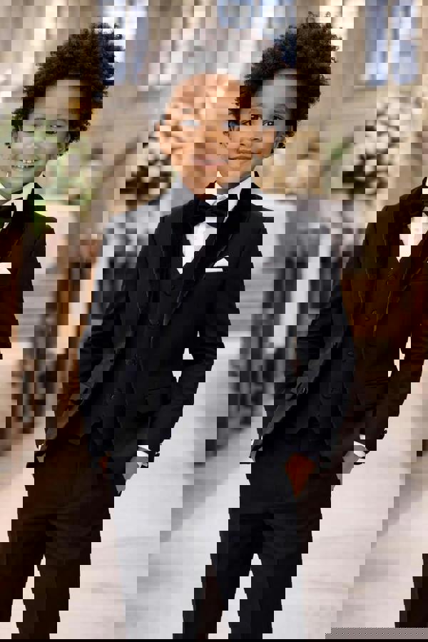 Child in a formal black suit standing in a church setting