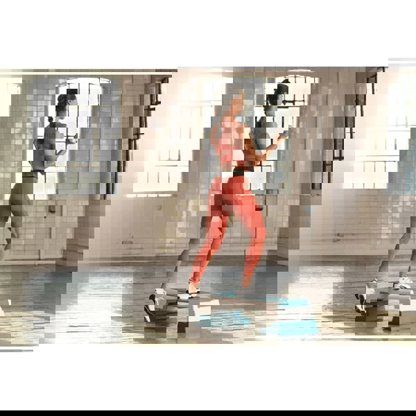 Woman performing a Reebok Step Workout - Teal