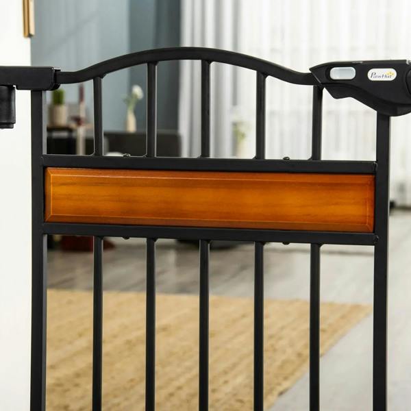 Black pet safety gate top handle and horizontal safety bar, close-up