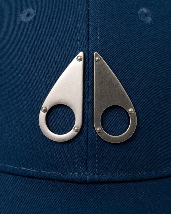 logo detail of a Moose Knuckles Front Logo Icon Cap in Nightfall 1977