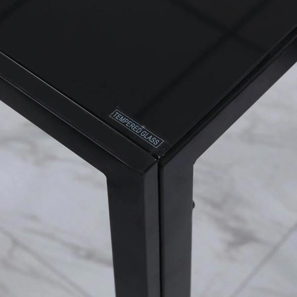 Corner detail of a black dining table with tempered glass top and metal frame