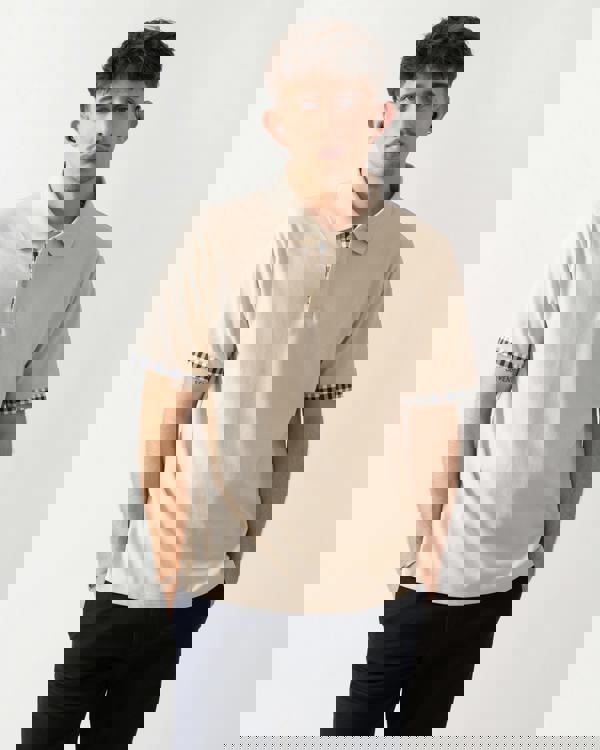 studio shot of a model wearing an Aquascutum Mens Club Check Stretch Piquet Sleeves Polo Shirt in Beige 03