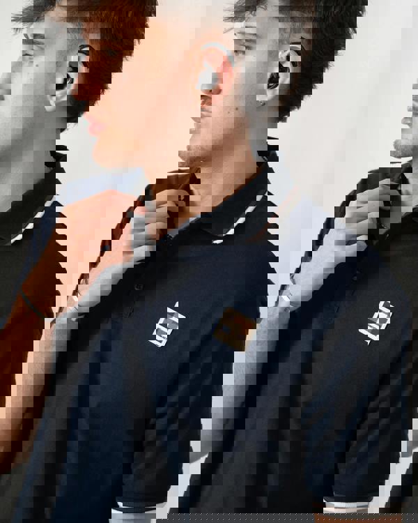 close up shot of a model wearing an Aquascutum Mens Stretch Piquet Tipped Badge Polo Shirt in Navy 11