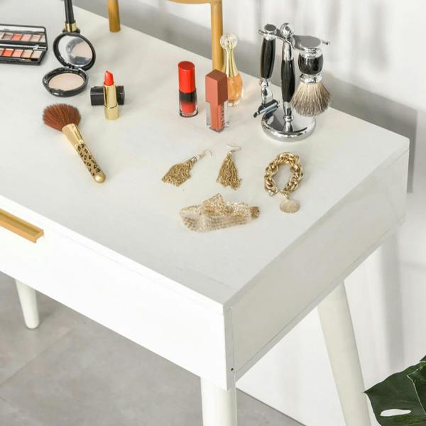 White dressing table top with cosmetics and accessories, gold handle detail visible