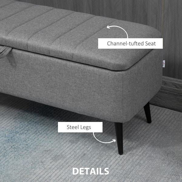Grey upholstered storage ottoman with channel-tufted seat and steel legs
