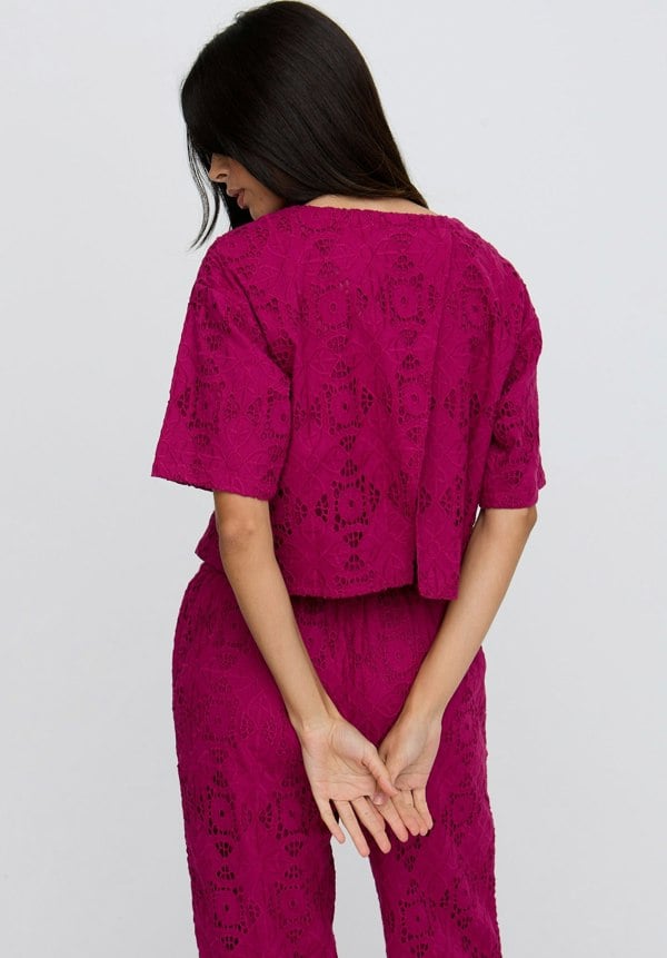 Woman wearing a pink patterned outfit on a white background