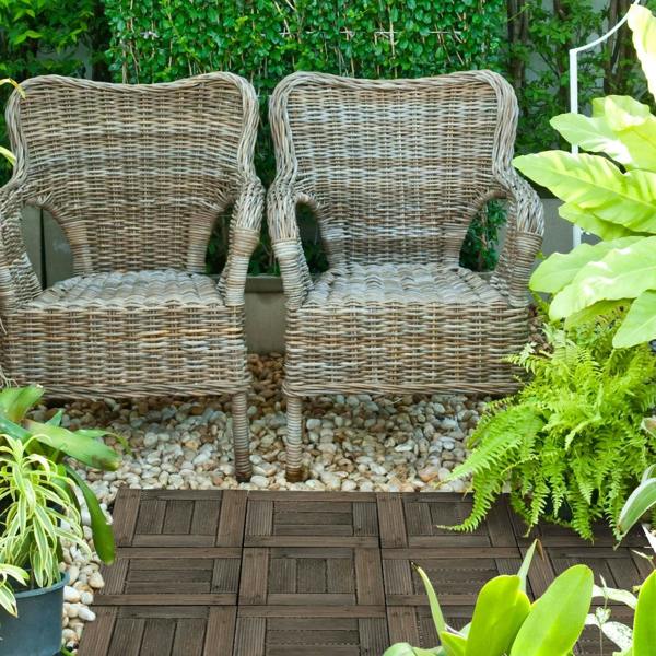 Charcoal grey patio decking tiles in a garden seating area on interlocking panel floor