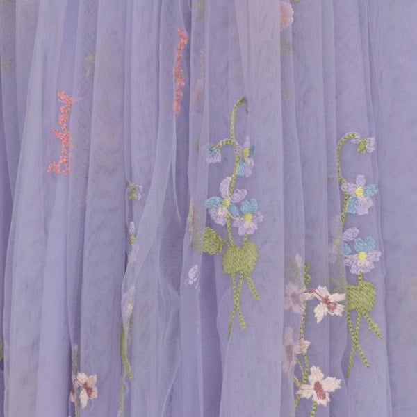 Embroidered floral design on a purple fabric