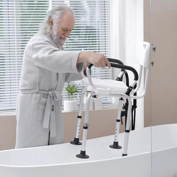 White shower chair with backrest and padded flip-up arms beside a bathtub