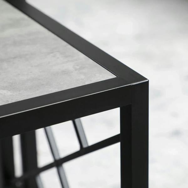Close-up of black metal table edge and open frame beneath grey tabletop