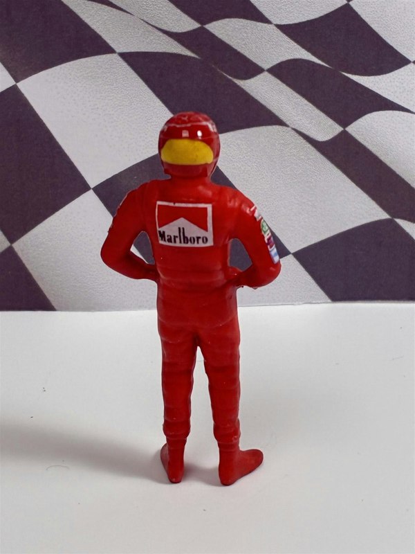 a toy figure of a man wearing a red suit