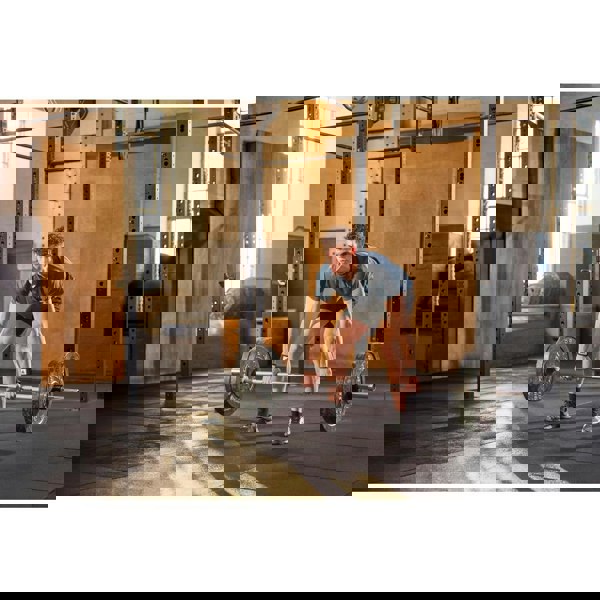 Man lifting a barbell in a gym setting wearing  adidas wrist wraps