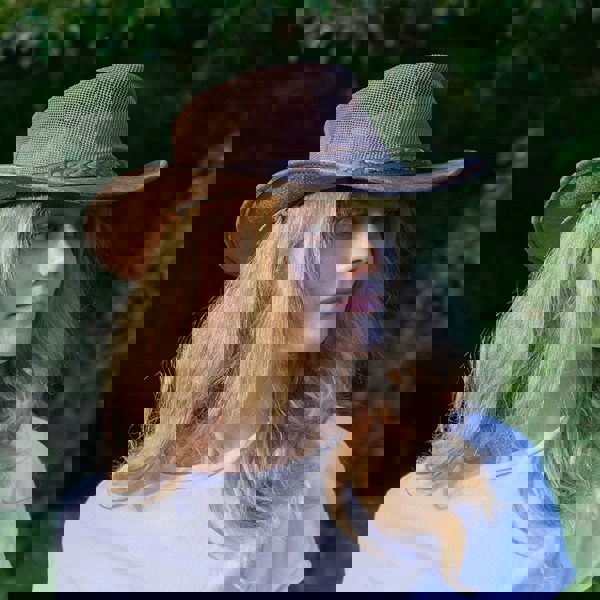 woman wearing a wombat the wilds air brown leather hat with mesh sides